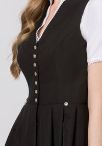 Black dress with a fitted bodice, silver buttons, and pleated skirt. White collar with lace trim adds detail. Smooth fabric texture.