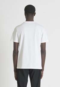 Witte katoenen t-shirt met korte mouwen en een klassieke ronde halslijn, gladde textuur en geen zichtbare patronen of hardware.