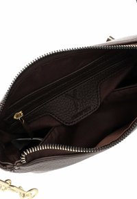 Bruine leren handtas met ritsluiting, voorzien van een textuurinterieur, een interne ritszak en een gouden kettinghengsel.