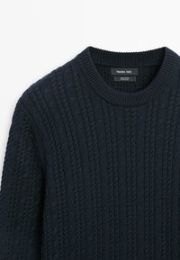 Tmavě modrý svetřík z bavlny s kabelovým vzorem, kulatým výstřihem a žebrovaným límcem, označený značkou Massimo Dutti, vyrobený v Číně.