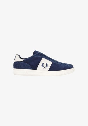 Zapatillas de ante azul marino con detalles en cuero blanco, diseño con cordones y logo bordado. Suela de goma con detalles texturizados.