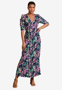 Maksi obleka v mornarsko modri barvi z barvitim cvetličnim vzorcem v roza, zeleni in breskvastih odtenkih. Ima globok V-izrez in napihnjene rokave. Mehek, teksturiran material.