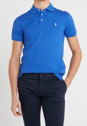 Polo bleu avec col et patte de boutonnage à trois boutons; présente un petit logo blanc sur la poitrine; tissu en mélange de coton, texture lisse.