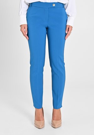 Blaue, figurbetonte Hosen mit einer glatten Textur, die einen einzelnen goldenen Knopf am Bund und einen knöchellangen Schnitt aufweisen.