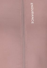 Veste de sport rose zippée avec une texture côtelée, dotée d'une fermeture éclair à l'avant et du mot "ENDURANCE" en blanc sur le côté gauche.