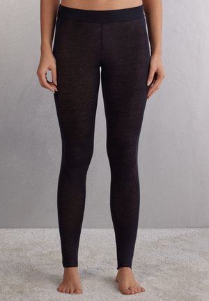 Schwarze Leggings aus einem weichen, dehnbaren Material mit einem hohen Bund. Der Stoff wirkt leicht durchsichtig und hat eine glatte Textur.
