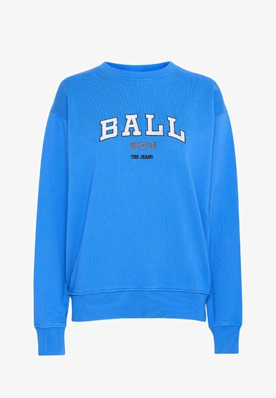 Zils džemperis ar apaļu kakla izgriezumu, uz kura ir izšuvums "BALL 1974" baltā un oranžā krāsā. Ribotie aproces un apakša, gluda auduma tekstūra.