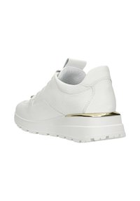 Witte sneaker met een gestructureerd bovenwerk, platte veters en een gouden accent op de zool. De zool heeft een geribbeld patroon voor grip.
