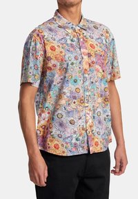 Košile s krátkým rukávem z lehké látky s vícebarevným květinovým vzorem, zapínáním na knoflíky vpředu a malou kapsou na prsou.