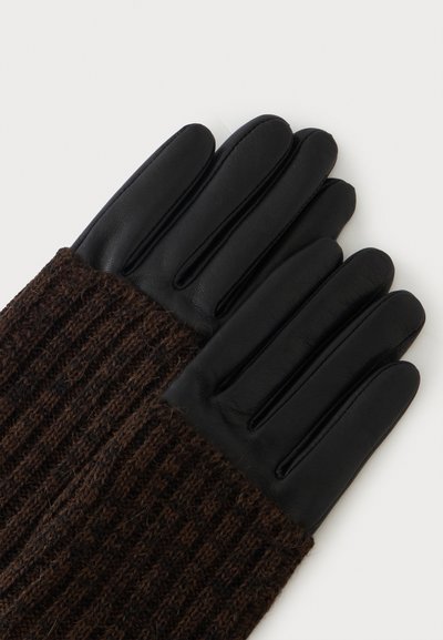 Paire de gants en cuir noir avec poignets tricotés marron posés à plat sur une surface claire.