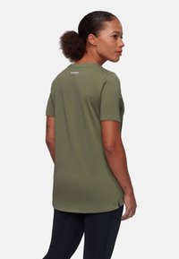 Olivengrøn kortærmet t-shirt med rund hals, subtilt logo på ryggen og en afslappet pasform. Fremstillet af blødt, åndbart stof.
