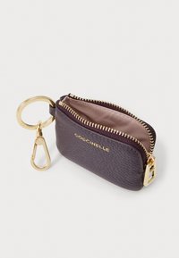 Pochette portachiavi in pelle di colore viola scuro, con hardware dorato, chiusura a zip e un piccolo attacco a clip. L'interno è foderato con un tessuto chiaro.