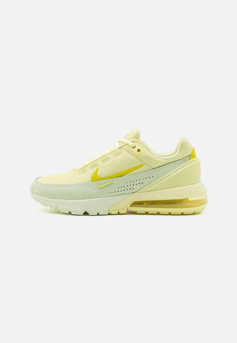 Chaussure de course en maille jaune avec des accents gris, tige texturée, logo Nike bien en vue et coussin d'air visible dans la semelle.