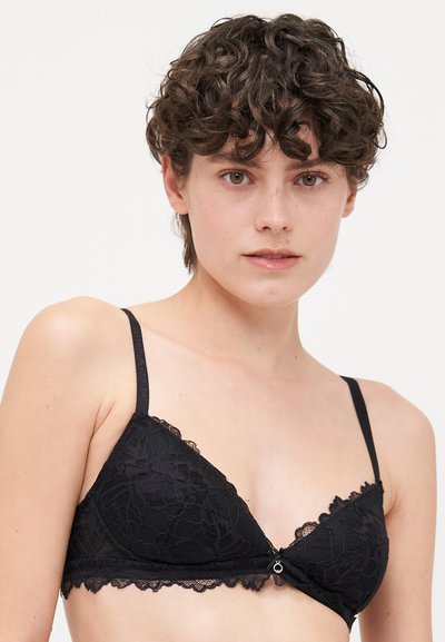 Black lace triangle bra featuring floral patterns, scalloped edges, adjustable straps, and a small metallic accent at the center.