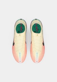 Nike tenisice za trčanje s laganim pletenim gornjim dijelom, gradijentnom bojom od ružičaste do krem, crnim swooshom i zelenim ulošcima s natpisom.