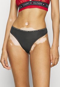 Zwarte katoenen bikini briefs met golvende kanten rand, voorzien van een merk-elastische tailleband in rood en zwart.