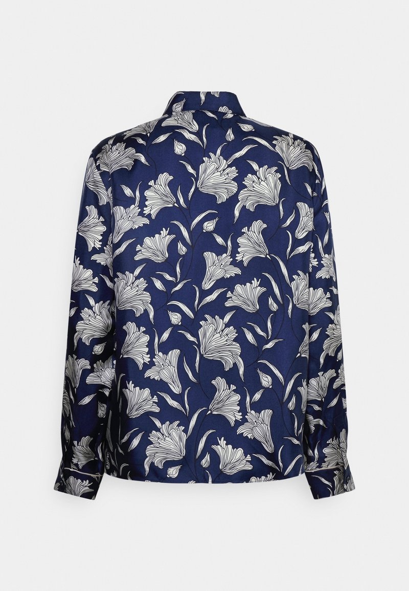 Blusa blu navy con motivo floreale bianco, maniche lunghe, design con colletto e texture liscia. La vista posteriore mostra una copertura floreale completa.