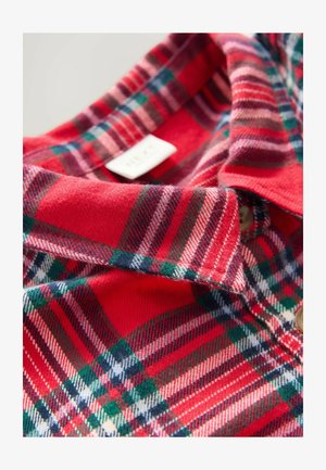 Punainen, vihreä ja valkoinen ruudullinen flanellipaita, jossa on kaulus ja yläosa näkyvillä nappilistoilla ja kankaan tekstuurilla.