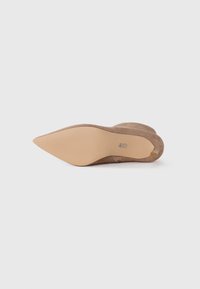 Brown suede stiletto heel with a pointed toe and a beige rubber sole featuring ridges for grip. Notable brand logo on the sole.