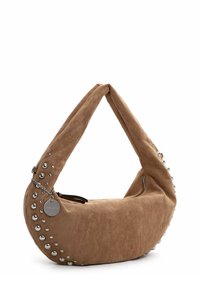 Brun suedette hobo taske med en rund form, dekoreret med sølvstuds langs den ene side og en kædeaccent fastgjort til en lynlås.