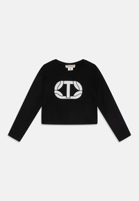 Black long-sleeve cropped t-shirt made of soft fabric, featuring a large white logo design on the front. Simple neckline and fitted sleeves.