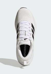 Zapatilla de running blanca con parte superior de malla transpirable, cordones en la parte delantera, acentos negros y suela texturizada. Presenta la marca "SUPERNOA" en la plantilla.