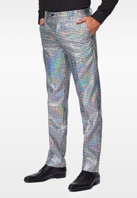 Silberne reflektierende Hose mit Karomuster, das aus Quadraten in verschiedenen Farben besteht. Schmale Passform, kombiniert mit schwarzen Schnürschuhen.