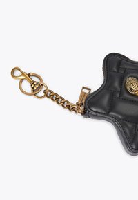 Czarna skórzana torba w kształcie gwiazdy z pikowaną fakturą i złotym łańcuchem. Posiada zapięcie na klips oraz dekoracyjny metalowy akcent.