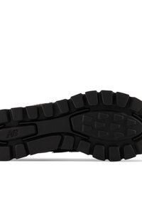 Czarna, wytrzymała gumowa podeszwa buta New Balance z głębokim bieżnikiem i trójkątnymi wzorami chwytu.