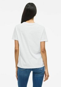 T-shirt en coton blanc à manches courtes et col rond, présenté de dos, avec une coupe décontractée et sans motifs ni graphismes visibles.