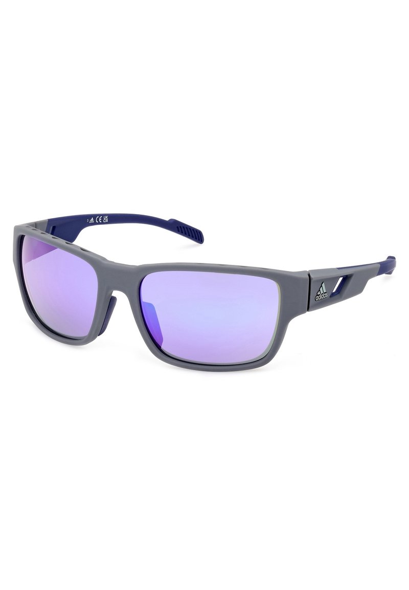 Harmaat muoviset aurinkolasit, joissa on polarisoidut laventelinväriset linssit. Niissä on geometrinen kehysmuotoilu ja teksturoidut tummansiniset temples. Logo sivussa.