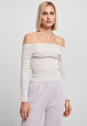 Off-shoulder långärmad topp i ljusgrå ribbad material, åtsittande design med en subtil textur. Matchas med mjuka lavendelfärgade sweatpants.