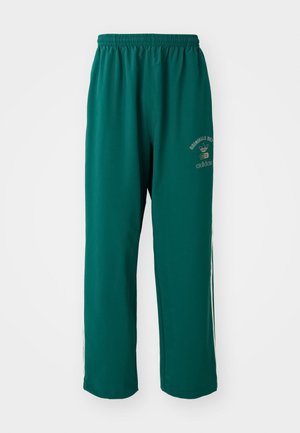 Pantalons de sport verts en tissu lisse, dotés d'une taille élastique, d'un logo imprimé sur un côté et de rayures blanches sur les côtés. Coupe régulière.
