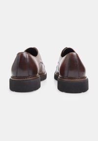 Scarpe in pelle marrone con punta arrotondata, dettagli di cucitura sottili e suola in gomma nera. Il design presenta una texture liscia e accenti minimi.