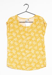 Gul blommig topp med rundad halsringning, korta ärmar och lös passform. Har ett mönster av små vita blommor på ett mjukt tyg.