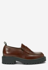 Mocassin en cuir marron à semelle en caoutchouc noire épaisse, coutures apparentes et languette à l’arrière, présenté sur fond blanc.