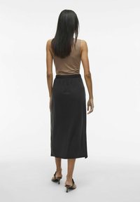 Black midi skirt with an elastic waistband, made from soft fabric, paired with a fitted brown tank top, viewed from the back.