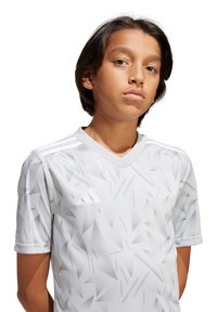 Witte korte mouwen jersey met een geometrisch patroon met scherpe hoeken, v-hals ontwerp en drie subtiele strepen op de schouders.