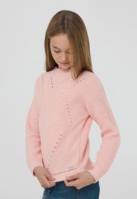 Różowy sweter z dzianiny z długimi rękawami, prążkowaną teksturą oraz ozdobnymi otwartymi detalami. Posiada okrągły dekolt i prosty krój.