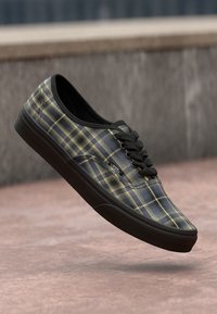 Black and yellow plaid canvas sneaker with black rubber sole, round toe, and classic lace-up design. Features subtle brand logo.