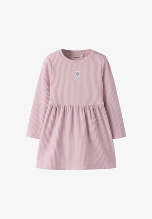 Sukienka z długim rękawem z prążkowanej, jasnoróżowej tkaniny z marszczonym pasem. Z przodu, na piersi, ma mały, haftowany fioletowy tulipan.