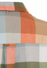 Tissu à carreaux aux nuances d'orange, bleu, vert et beige ; comprend un col pointu et des coutures visibles sur les bords.