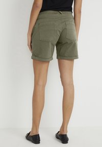 Khaki šortky s ohrnutým lemem, disponující dvěma zadními kapsami, šitými detaily a měkkým bavlněným materiálem.