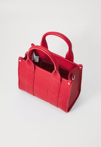 Bolsa de couro vermelha com duas alças arredondadas, logotipo em relevo na parte frontal e bolso interior com fecho. Design elegante e estruturado.