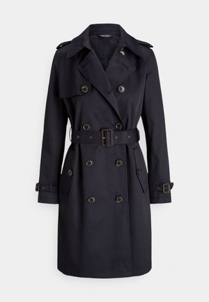 Trench-coat bleu marine foncé en tissu texturé, doté d'un design à double boutonnage, de grands boutons et d'une ceinture assortie avec une boucle rectangulaire.