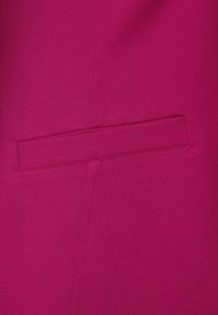 Fuchsiová tkanina se hladkým texturem, která obsahuje skrytou kapsu a čisté švy podél švu, zdůrazňující jak profesionální design.
