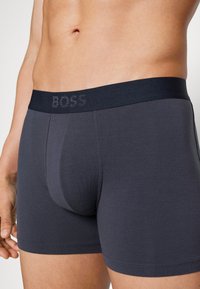 Boxers em mélange de algodão cinza escuro com uma cintura macia apresentando "BOSS". Textura suave, design ajustado e um bolso contornado na parte da frente.