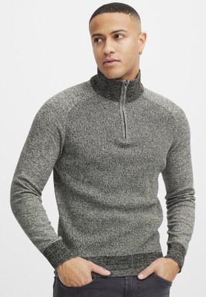 Knitted quarter-zip sweater in mottled grey and black fabric. Features ribbed cuffs and hem, with a high collar and zipper detail.