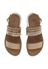 Tan leather sandals with braided decorative strap featuring metallic accents and small hanging charms. Flat sole, open back design.