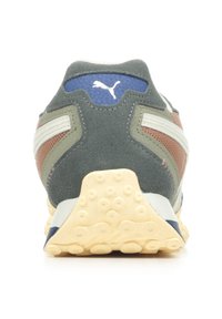 Sneaker con tomaia in suede verde e marrone, dettagli a strisce bianche e un'etichetta con logo blu testurizzato. Suola in gomma crema con motivi antiscivolo.